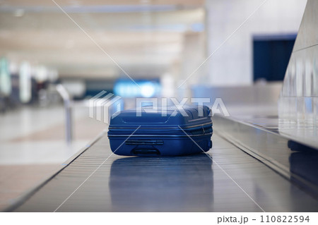Lonely blue suitcase on baggage claim at airport. 110822594