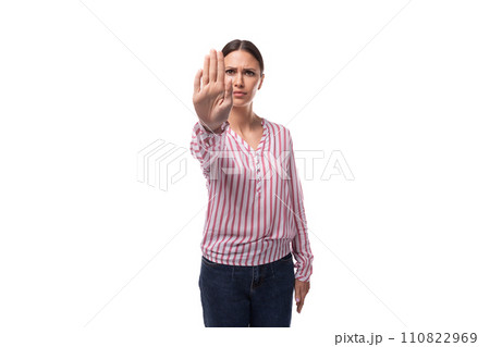 portrait of a young brunette office worker woman dressed in a shirt with stripes pointing stop 110822969