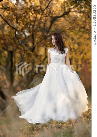 beautiful sensual bride in white wedding dress standing outdoor on natural background 110823255