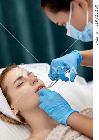 beautician makes injections to enlarge the lips of beautiful woman. procedure lip augmentation beautician makes injections to enlarge the lips of beautiful woman. procedure lip augmentation 110823290