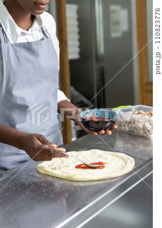 Female pizzeria cook preparing pizza in the kitchen 110823776