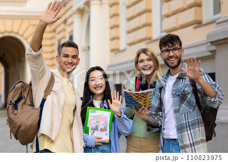 College multiethnic students standing in campus with books and backpacks. 110823975