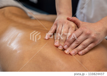 Close up of massage therapist hands doing back massage 110824437
