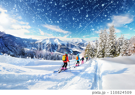 雪が舞うスキー場でスキーをする人々 110824509