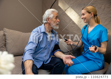 Nurse examining mature patient measuring blood pressure. Nurse examining mature patient measuring blood pressure. 110824773