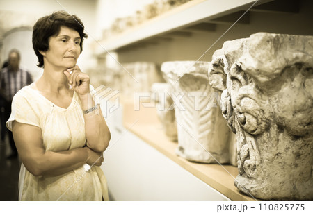 Female evaluates the exhibition in historical museum 110825775