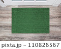 Green Coir Doormat on a wooden floor in front of the door. Product mockup 110826567