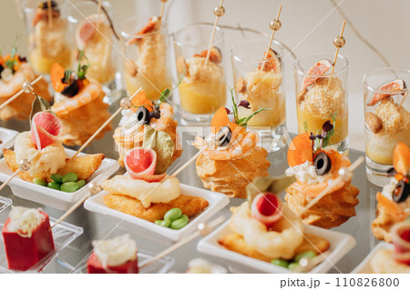 Assortment of delicious snacks on the open buffet festive table in restaurant. Catering plate 110826800