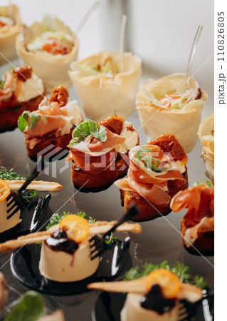 Assortment of delicious snacks on the open buffet festive table in restaurant. Catering plate Assortment of delicious snacks on the open buffet festive table in restaurant. Catering plate 110826805