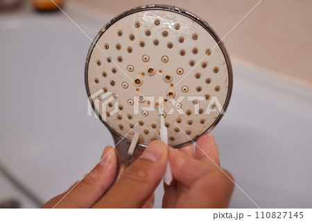 Detail cropped shot of unrecognizable man in protective gloves cleaning calcified shower head using small brush ruff Detail cropped shot of unrecognizable man in protective gloves cleaning calcified shower head using small brush ruff 110827145