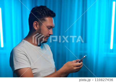 Portrait of a cheerful man using smart phone at home office. 110827436