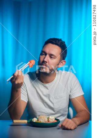 Unrecognizable man eating poke bowl with salmon,avocado,seaweed 110827498