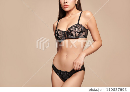 Confident beautiful young asian woman posing in black lingerie on beige background, Perfect body, 110827698