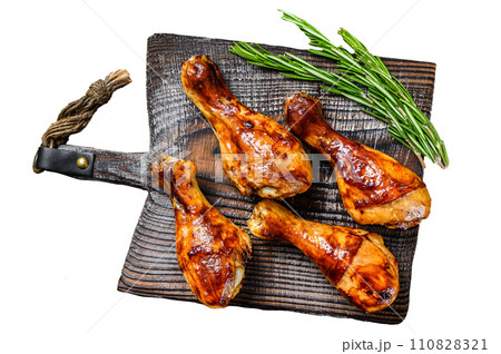 Barbecue roasted chicken drumsticks on a wooden cutting board. Isolated on white background, Top view. 110828321