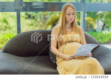 Expectant woman reviews her blood test results, contemplating the health of her pregnancy 110828498