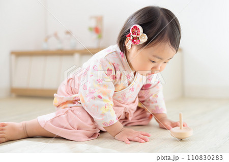 回るコマを眺める乳幼児 1歳 正月遊び 回るコマを眺める乳幼児 1歳 正月遊び 110830283