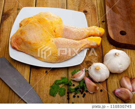 Raw chicken leg quarters on wooden table 110830745