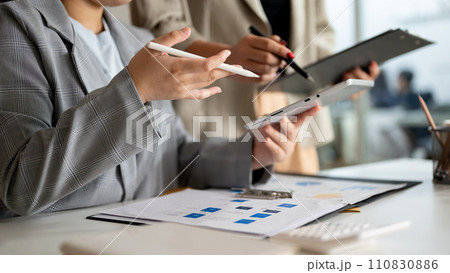 Two focused businesswomen or female accountants are brainstorming and working in the office together 110830886