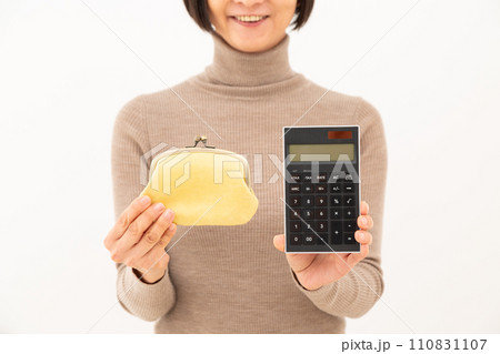 黒い電卓とがま口財布を持って微笑むミドル女性 黒い電卓とがま口財布を持って微笑むミドル女性 110831107