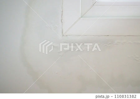 house wall near the window with some water stain show peeling paint house wall near the window with some water stain show peeling paint 110831382
