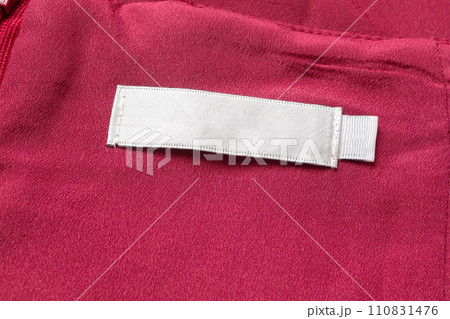 Blank white laundry care clothes label on red fabric texture background Blank white laundry care clothes label on red fabric texture background 110831476