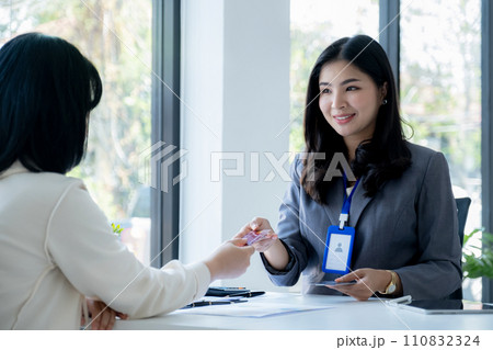 Employees present with mock up credit card payments to business customers. Ready to provide discounts and life insurance Employees present with mock up credit card payments to business customers. Ready to provide discounts and life insurance 110832324