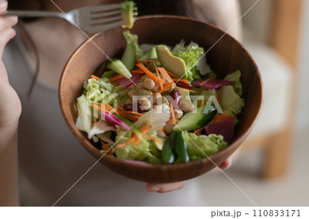 サラダを食べる若い女性の手元 110833171