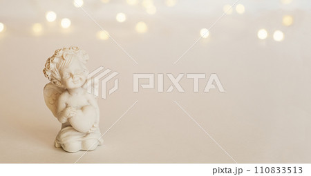 figurine of an angel Cupid with a bow on a pink background. Valentine's Day. 110833513