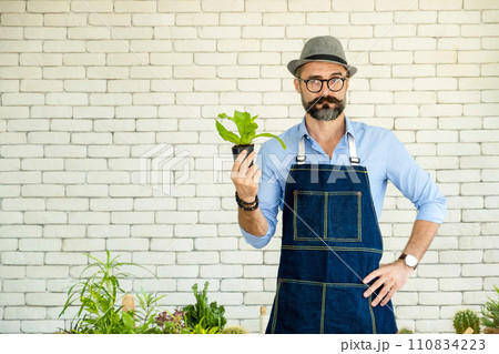 Hipster elderly men take care of the trees, a hobby of urban home gardening after sustainable retirement Hipster elderly men take care of the trees, a hobby of urban home gardening after sustainable retirement 110834223