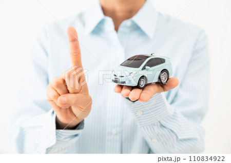 自動車の模型を持って人差し指を立てるミドル女性 自動車の模型を持って人差し指を立てるミドル女性 110834922