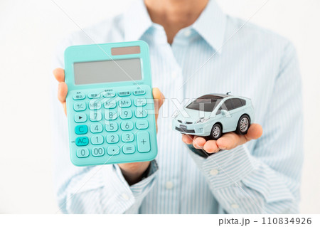 電卓と自動車の模型を持つミドル女性 電卓と自動車の模型を持つミドル女性 110834926
