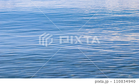 Blue sea in sunshine glow as surface background. Summer holidays and coastal nature concept 110834940