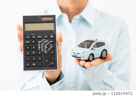 電卓と自動車の模型を持つミドル女性 110834972