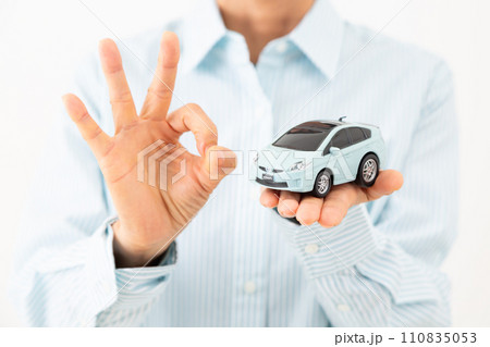 自動車の模型を持って丸サインをするミドル女性 自動車の模型を持って丸サインをするミドル女性 110835053