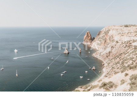 Aerial view from above on calm azure sea and volcanic rocky shores. Small waves on water surface in motion blur. Nature summer ocean sea beach background. Nobody. Holiday, vacation and travel concept Aerial view from above on calm azure sea and volcanic rocky shores. Small waves on water surface in motion blur. Nature summer ocean sea beach background. Nobody. Holiday, vacation and travel concept 110835059