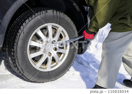 タイヤのナットをトルクレンチで締める男性 110838034