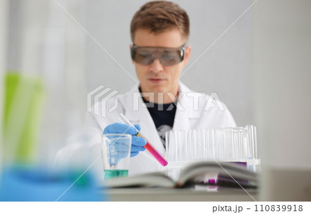 A male chemist holds test tube of glass 110839918