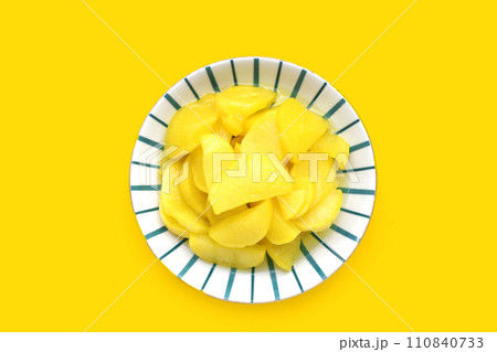Sweet and tart slices of yellow pickled daikon, known as takuan in Japan and danmuji in Korea. Sweet and tart slices of yellow pickled daikon, known as takuan in Japan and danmuji in Korea. 110840733
