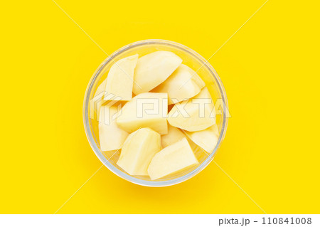 Raw peeled potatoes on yellow background 110841008