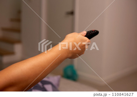 Hand holding TV remote control 110841627