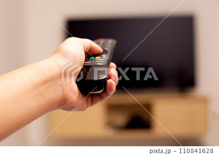 Hand holding TV remote control 110841628