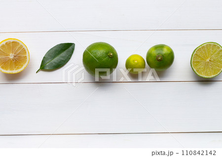Ripe lemons and limes on white wooden. Ripe lemons and limes on white wooden. 110842142
