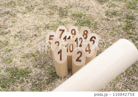 芝生に並べた12本のスキットルとモルック　 110842758
