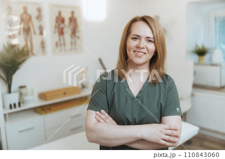 smiling female medical massage therapist looking at camera 110843060