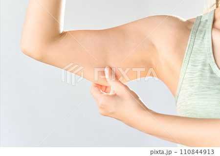二の腕のたるみを伸ばす女性 二の腕のたるみを伸ばす女性 110844913