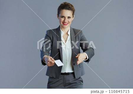 happy young woman worker in grey suit isolated on gray happy young woman worker in grey suit isolated on gray 110845715