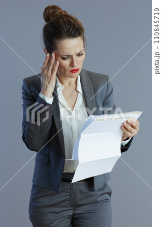 trendy female worker in gray suit isolated on grey 110845719