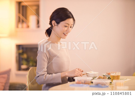 作り置きのお料理で夕食をとるビジネスウーマンのナイトルーティーン 110845801