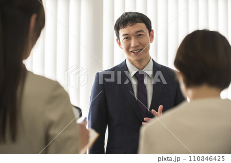 朝礼・ミーティングするスーツ姿の男女 110846425