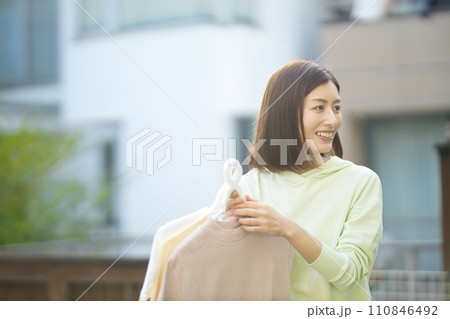 洗濯物を持つミドルの女性 洗濯物を持つミドルの女性 110846492